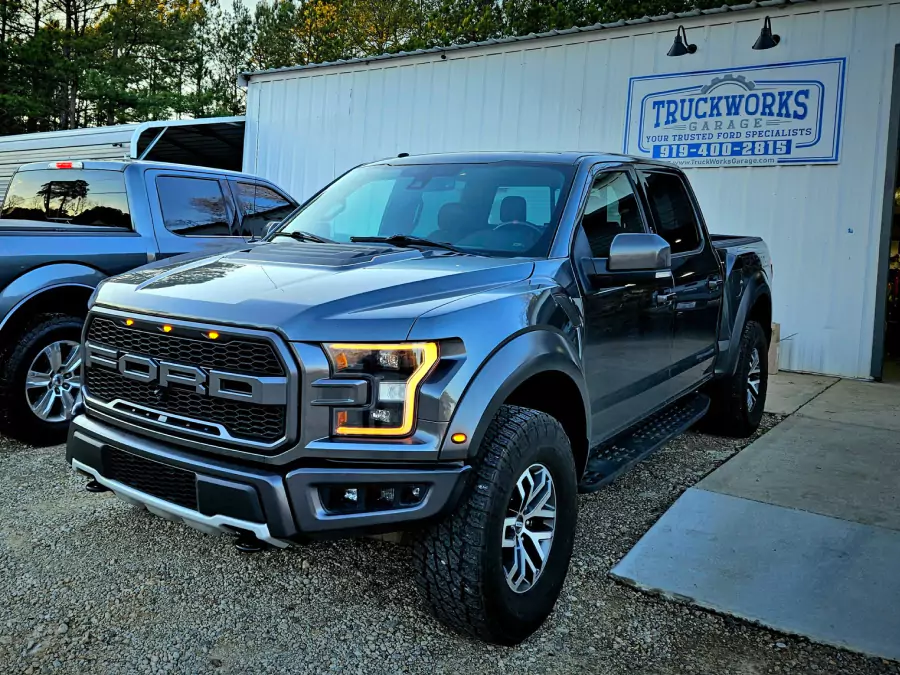 Black ford truck in front of truckworks garage